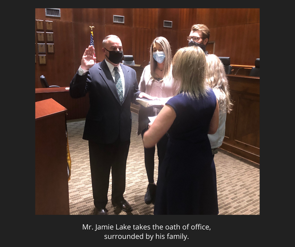 photo of Mr. Lake taking oath of office, surrounded by family. photo of Mr. Lake taking oath of office, surrounded by family.